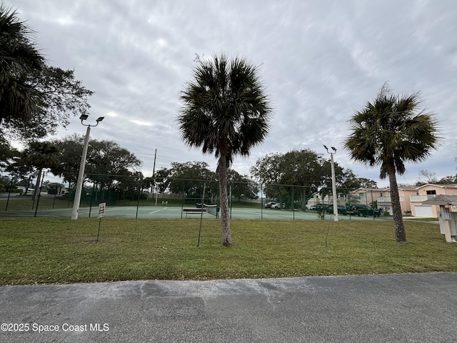 view of home's community with a lawn and tennis court