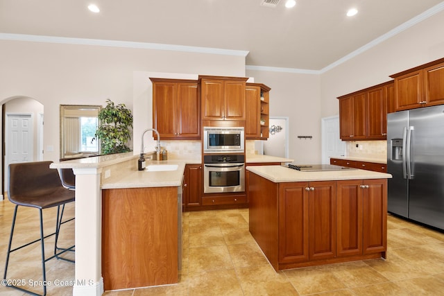 kitchen with a breakfast bar, sink, crown molding, kitchen peninsula, and stainless steel appliances