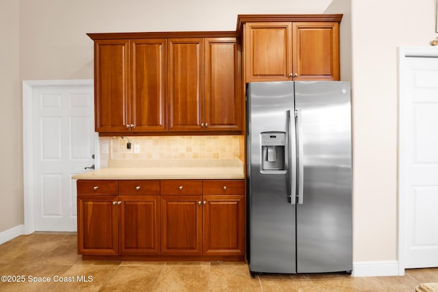 kitchen with stainless steel fridge with ice dispenser and decorative backsplash