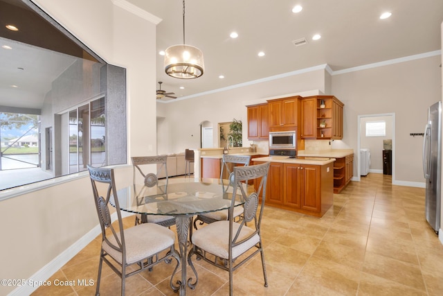 tiled dining room with ornamental molding, a wealth of natural light, and ceiling fan with notable chandelier