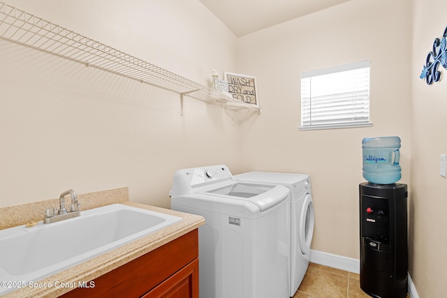 clothes washing area featuring sink, light tile patterned floors, cabinets, and independent washer and dryer