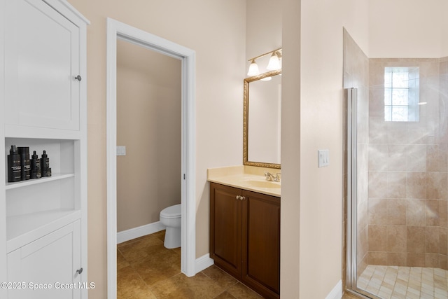 bathroom with toilet, built in shelves, vanity, and walk in shower