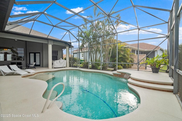 view of swimming pool with pool water feature, a patio, and glass enclosure