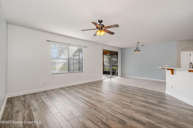 unfurnished living room with ceiling fan and light hardwood / wood-style flooring