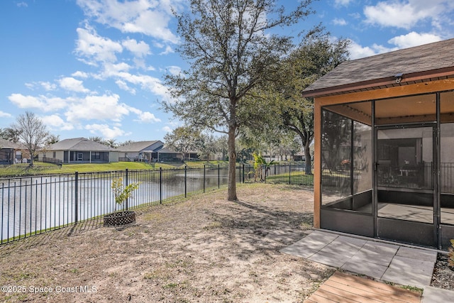 view of yard featuring a water view and a sunroom