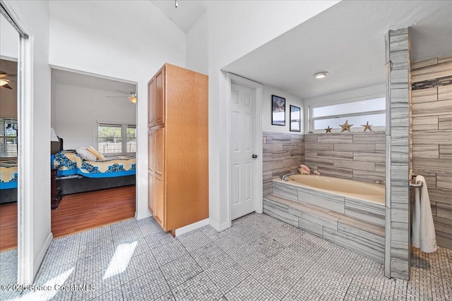 bathroom with tile patterned floors, tiled bath, and ceiling fan