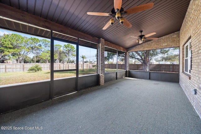 unfurnished sunroom with vaulted ceiling, a healthy amount of sunlight, and ceiling fan