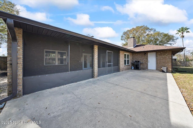 rear view of house with a patio and a sunroom