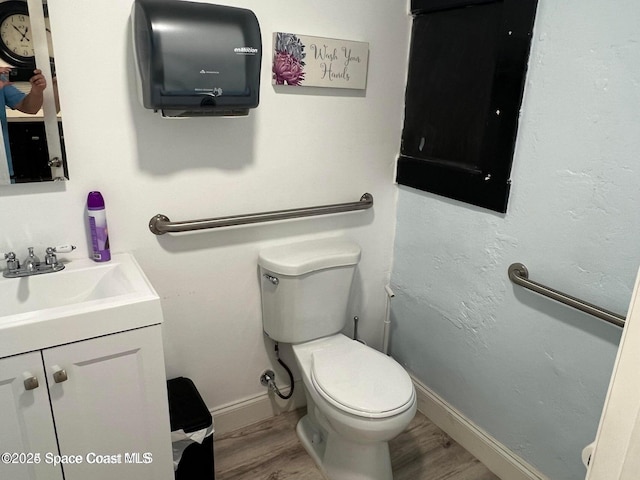 bathroom featuring toilet, hardwood / wood-style flooring, and vanity