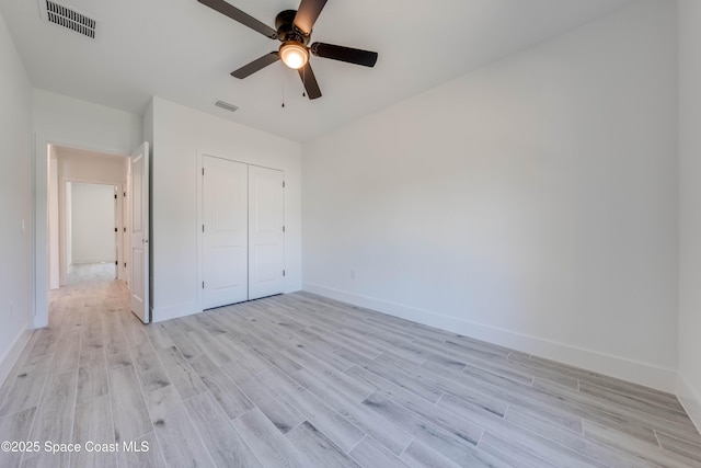 unfurnished bedroom featuring ceiling fan, a closet, and light hardwood / wood-style floors