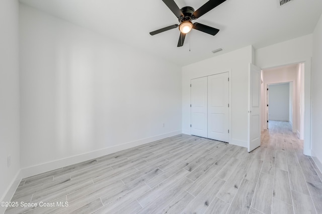 unfurnished bedroom featuring ceiling fan, a closet, and light hardwood / wood-style floors