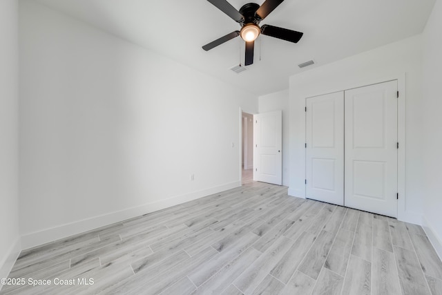 unfurnished bedroom featuring light wood-type flooring, ceiling fan, and a closet