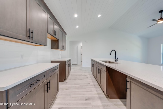 kitchen featuring wood ceiling, sink, vaulted ceiling, ceiling fan, and light hardwood / wood-style flooring