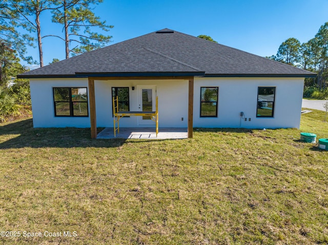 rear view of property featuring a lawn and a patio