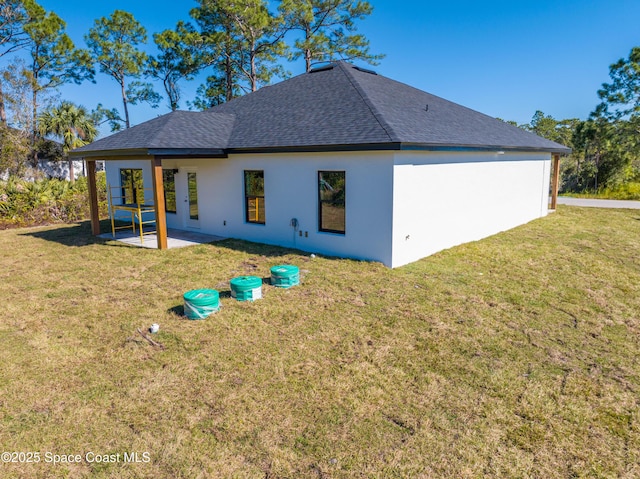 rear view of house with a yard and a patio