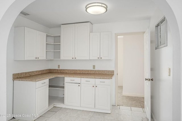 kitchen with light tile patterned floors and white cabinets