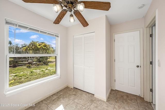 unfurnished bedroom with light tile patterned floors, a closet, and ceiling fan