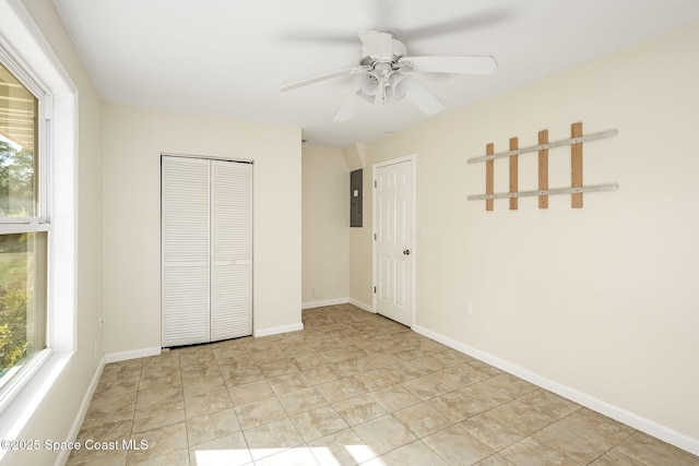 unfurnished bedroom with ceiling fan, electric panel, a closet, and light tile patterned floors