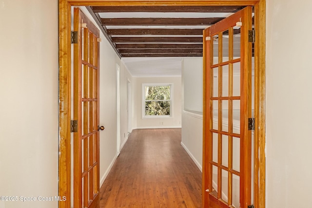 corridor with hardwood / wood-style flooring and beam ceiling