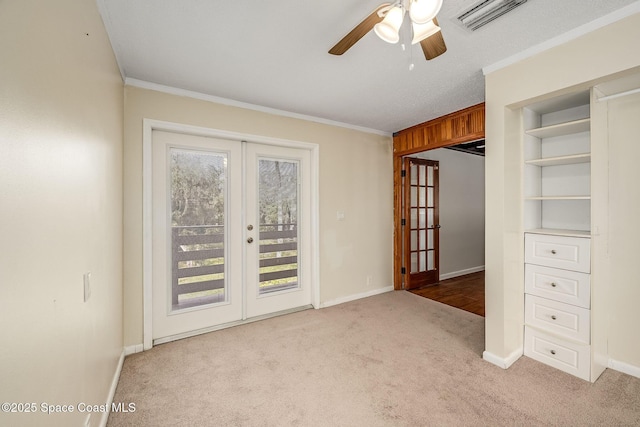 empty room with french doors, light colored carpet, crown molding, and ceiling fan