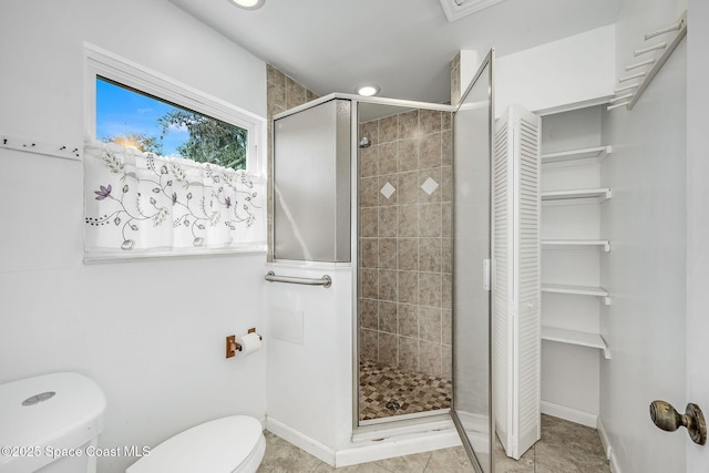 bathroom with tile patterned flooring, toilet, and walk in shower