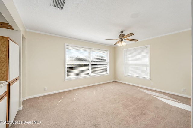 spare room with crown molding, light colored carpet, and ceiling fan