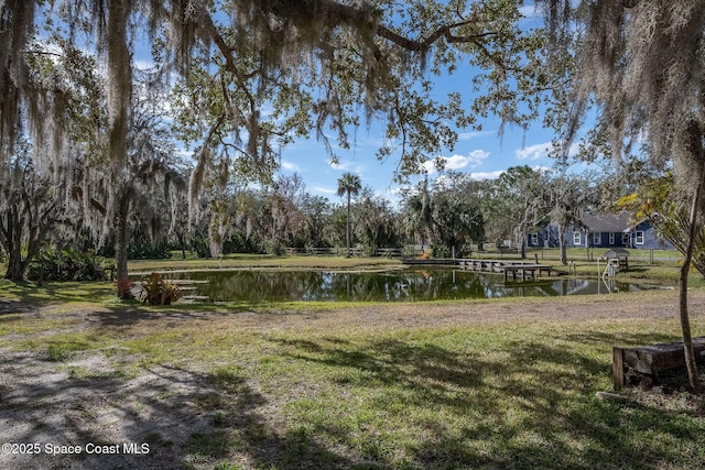 view of property's community with a lawn and a water view