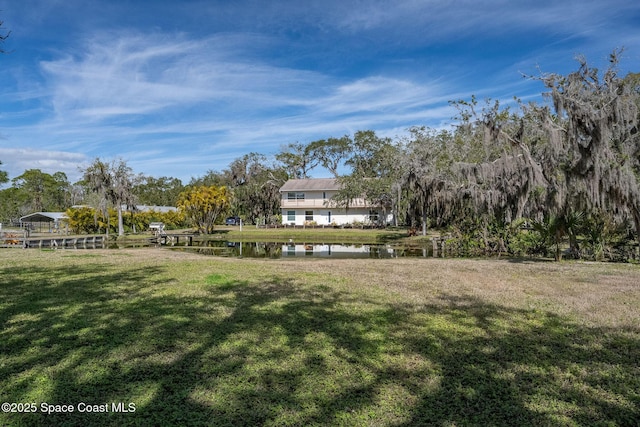 view of home's community with a lawn and a water view