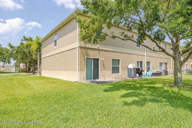 back of property featuring a lawn and central AC