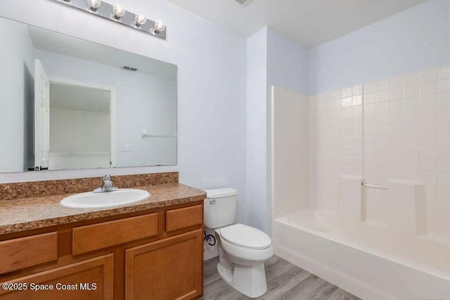 full bathroom with bathing tub / shower combination, toilet, hardwood / wood-style floors, and vanity