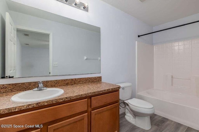 full bathroom with wood-type flooring, toilet, shower / tub combination, and vanity