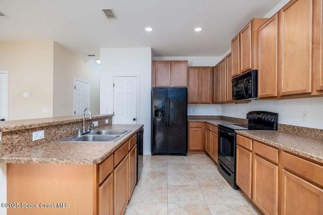 kitchen featuring black appliances, a kitchen island with sink, light tile patterned floors, and sink