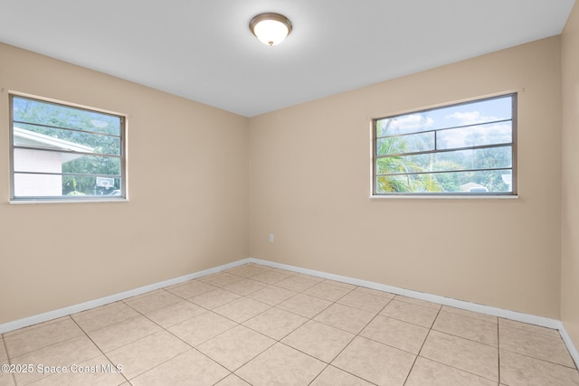 spare room with a wealth of natural light and light tile patterned flooring