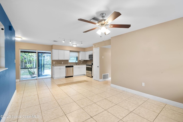 kitchen with ceiling fan, white cabinetry, light tile patterned floors, decorative backsplash, and stainless steel appliances