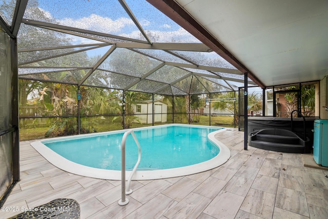 view of pool featuring glass enclosure, a patio area, and a shed