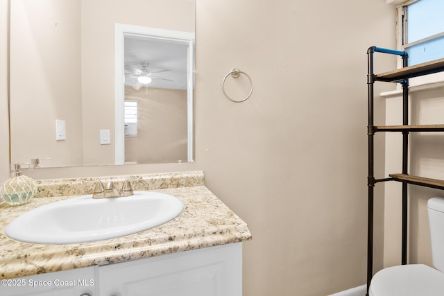 bathroom with vanity, toilet, and ceiling fan