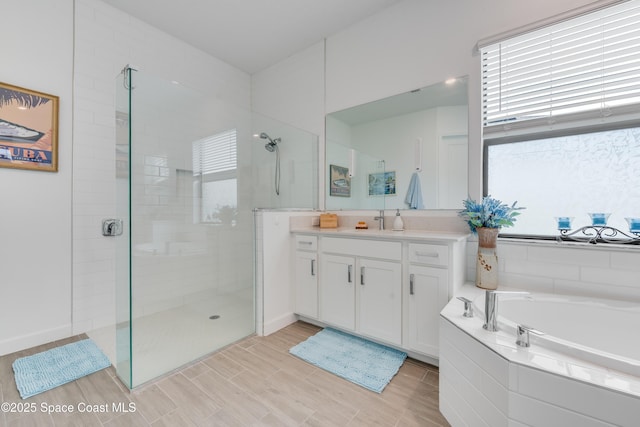 bathroom with a wealth of natural light, vanity, and shower with separate bathtub