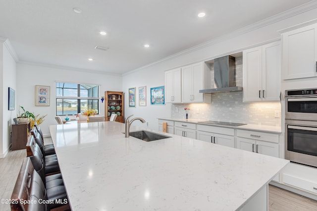 kitchen featuring white cabinets, double oven, wall chimney exhaust hood, and sink