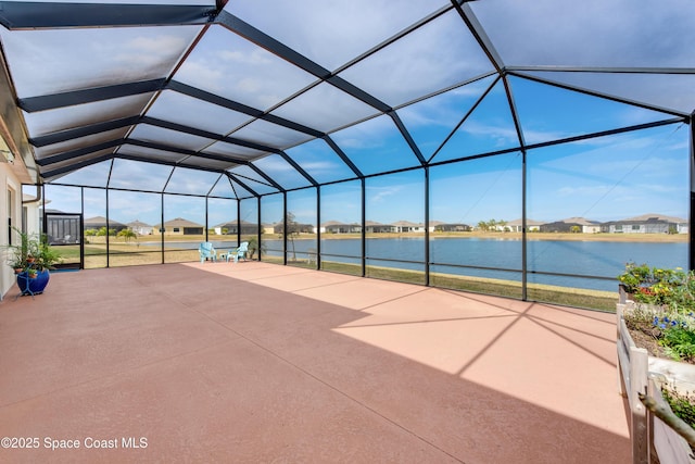 view of patio with a lanai and a water view