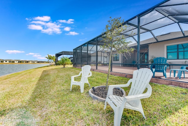 view of yard featuring a lanai, a patio area, and a water view