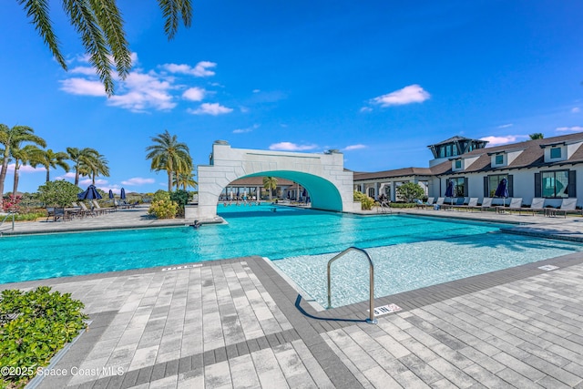 view of swimming pool with a water slide and a patio