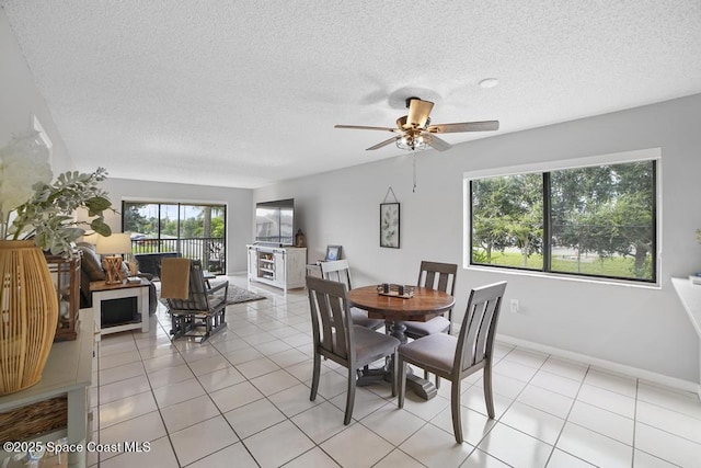 dining space featuring a textured ceiling, ceiling fan, and light tile patterned flooring