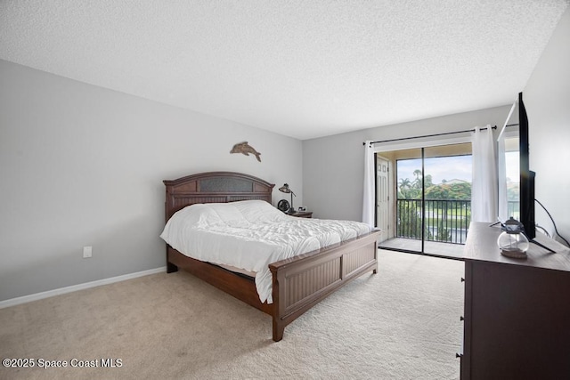 bedroom featuring a textured ceiling, light colored carpet, and access to outside