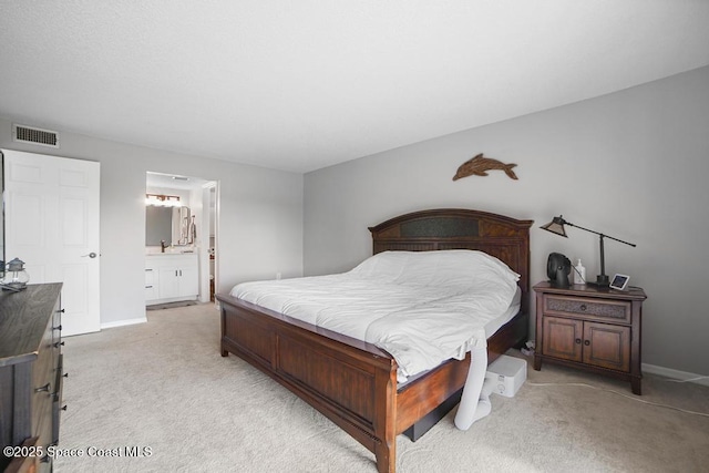 bedroom featuring light carpet and connected bathroom