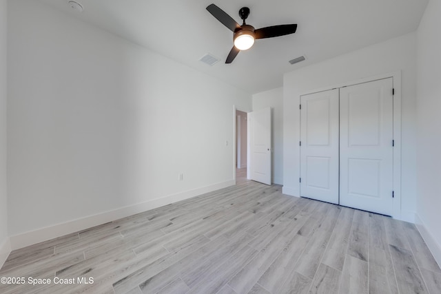 unfurnished bedroom with a closet, light hardwood / wood-style flooring, and ceiling fan