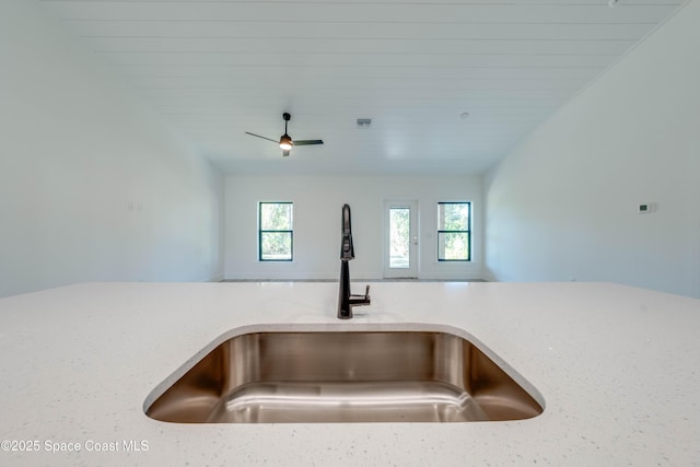 room details featuring ceiling fan, light stone countertops, wood ceiling, and sink