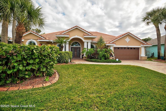 mediterranean / spanish home featuring a garage, a front yard, and french doors