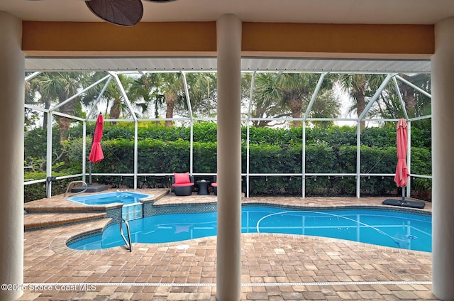 view of swimming pool featuring a lanai, a patio area, ceiling fan, and an in ground hot tub