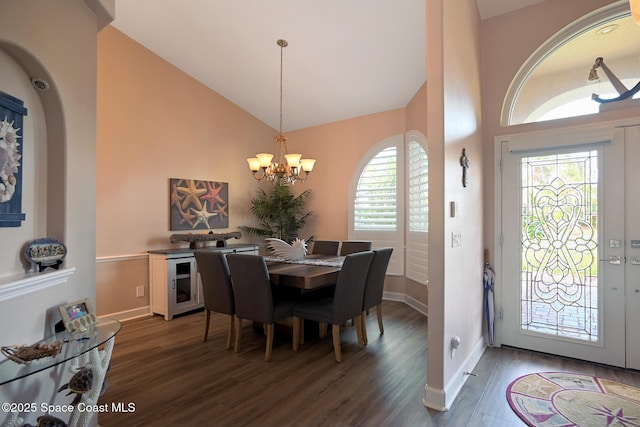 dining space with dark hardwood / wood-style floors, a chandelier, and high vaulted ceiling