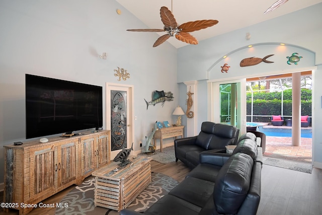 living room with wood-type flooring, high vaulted ceiling, and ceiling fan